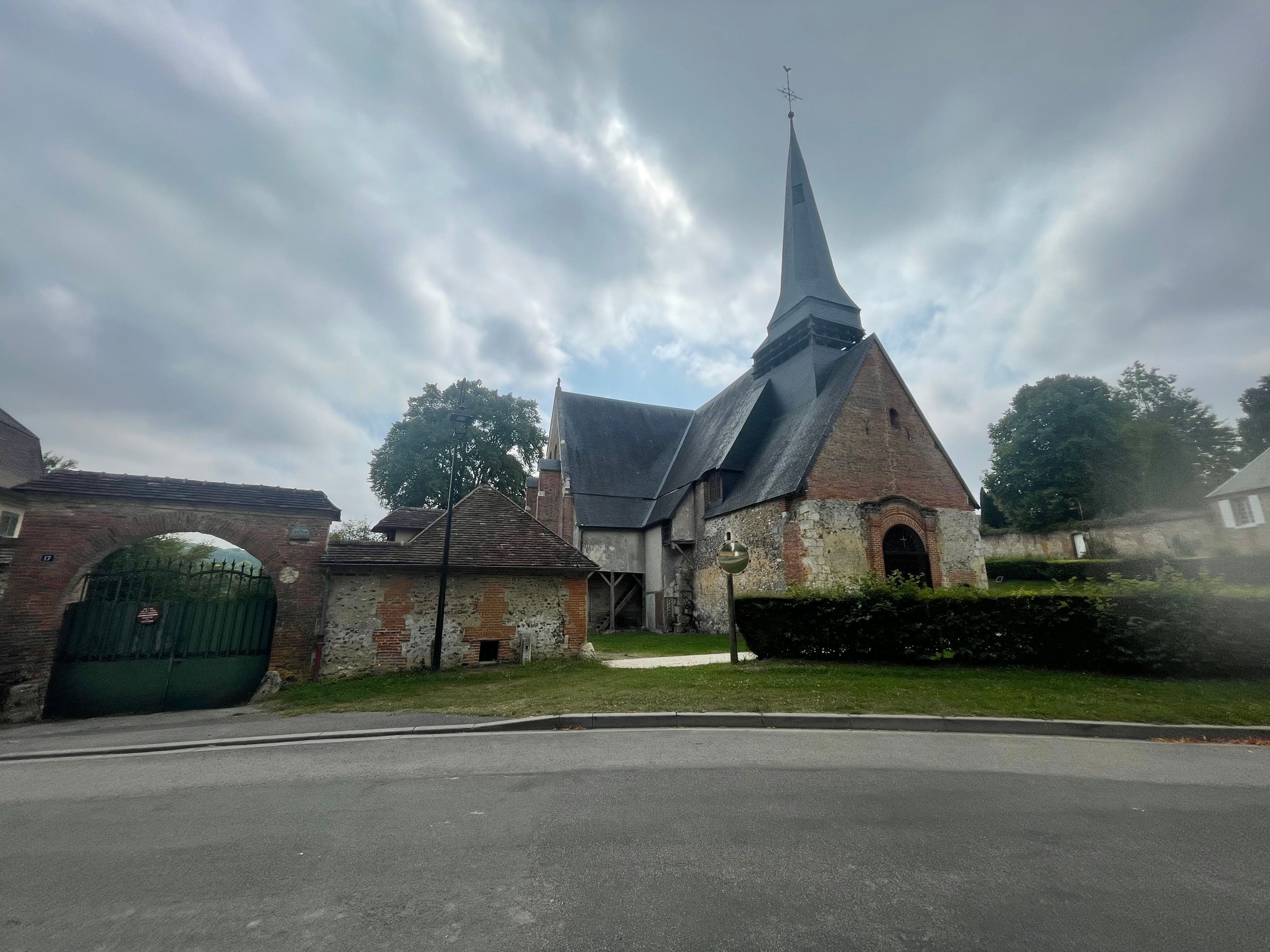 Une autre église typique de la région, en brique, pierres blanche et ardoises. L'image est floue à droite, suggérant un objectif sale.
